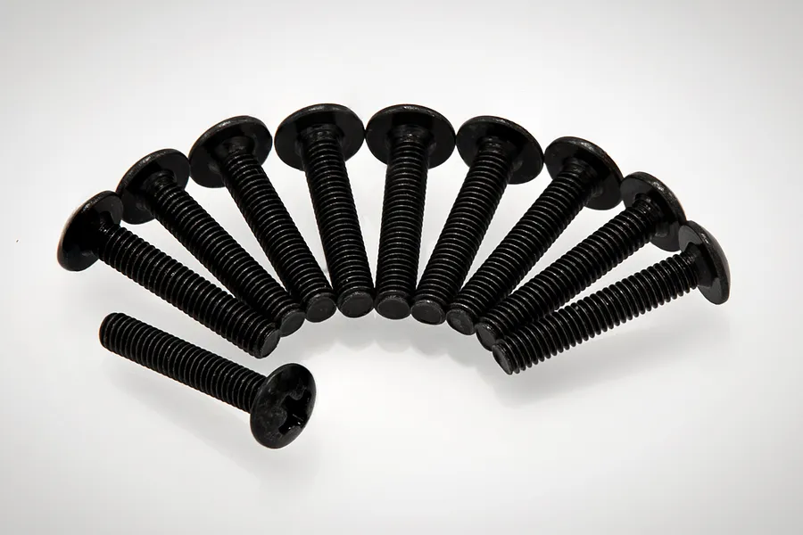 A set of ten black metal button head screws arranged in a semi-circle on a white background.