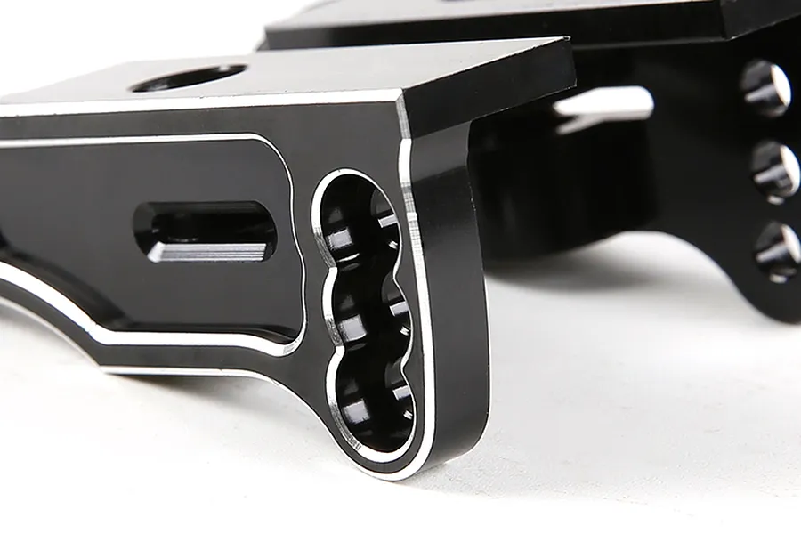 Close-up of a black anodized aluminium rear wing mount for an RC car, showing machined edges and mounting holes.