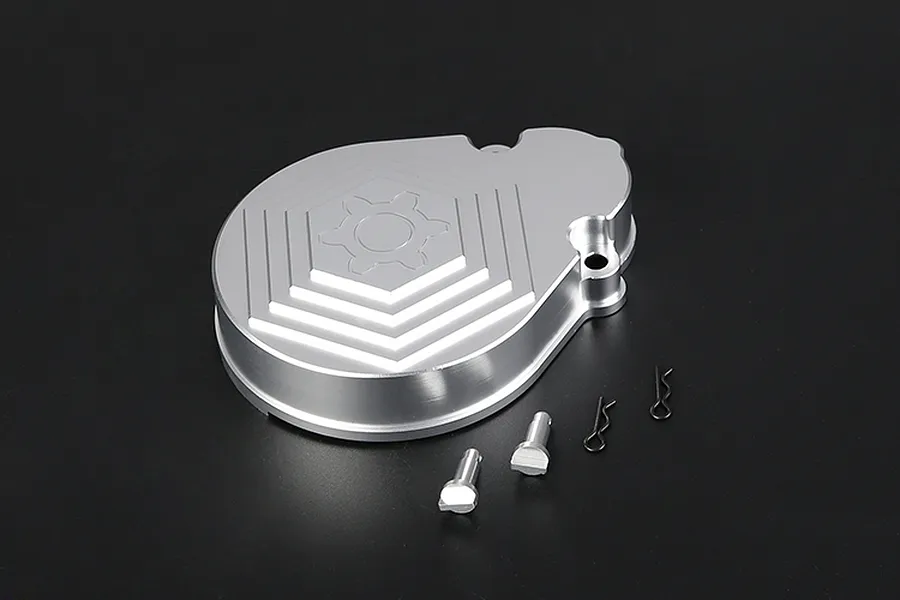 A silver aluminium Rovan RC transmission case cover with a gear logo, accompanied by two small metal pins and two R-clips on a black background.