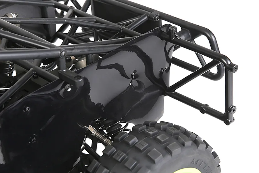 Close-up of a black plastic dust guard installed on the rear chassis of an RC buggy, showing the protective panel mounted near the rear wheel and roll cage.