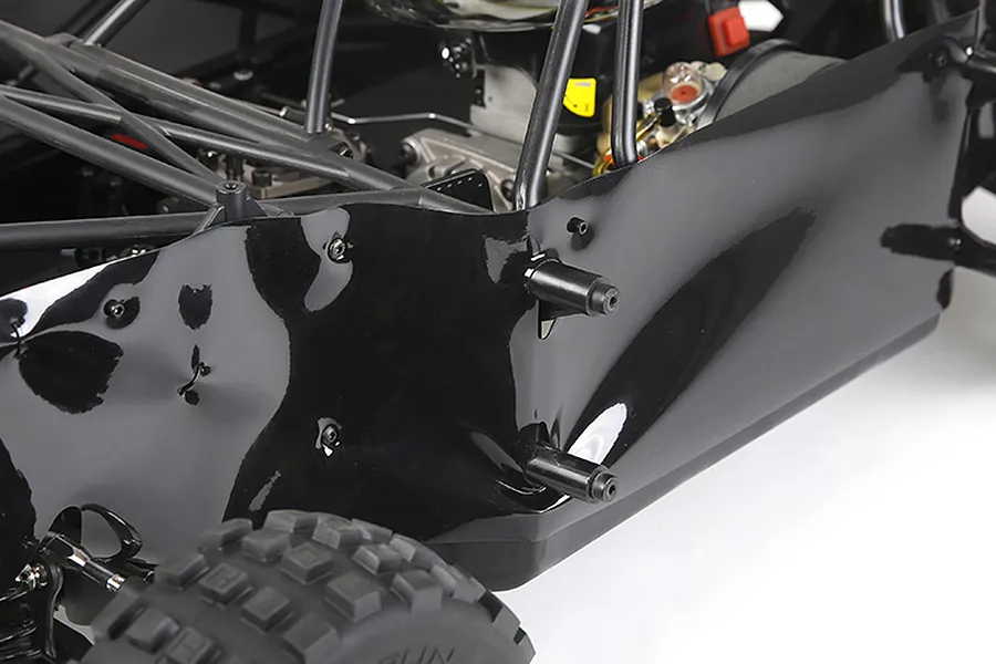 Close-up of a black plastic dust guard installed on the side of an RC buggy chassis.