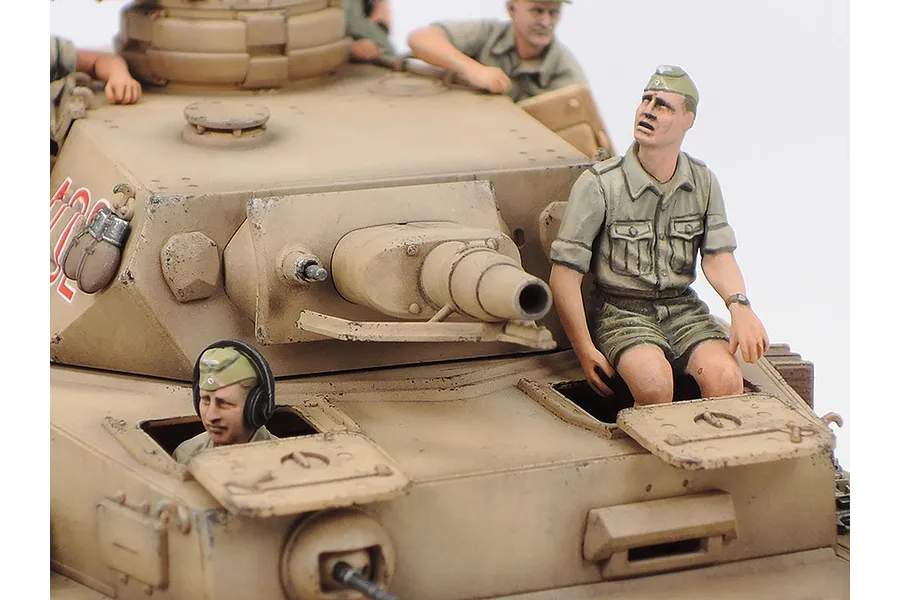 Close-up of a painted 1/35 scale Tamiya Panzer IV tank model with crew figures in desert uniforms.