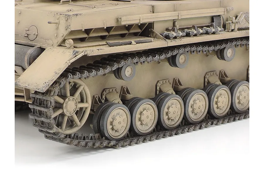 Close-up of the side profile of a Tamiya 1/35 scale Panzer IV Ausf.F tank model, showing the tracks, road wheels, and weathered tan hull.