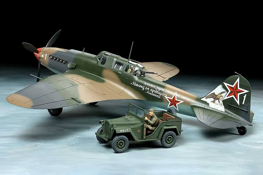 A completed 1/48 scale model kit of a Soviet Ilyushin Il-2 Shturmovik aircraft and a Gaz 67B utility vehicle with figures.