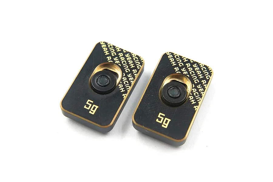 Two rectangular Yeah Racing 5g black brass chassis balancing weights with gold text and central mounting holes on a white background.