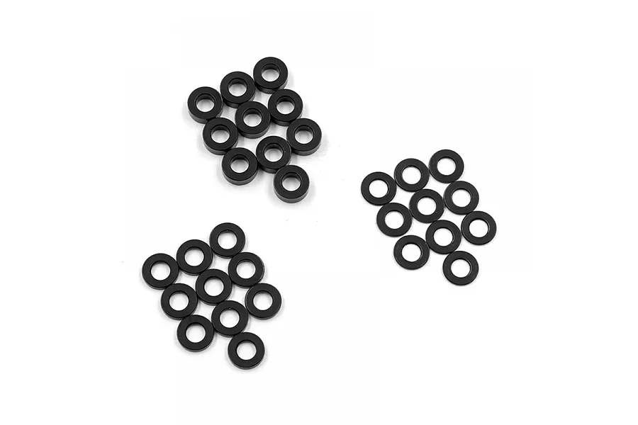 A collection of small black aluminium flat washers arranged in three groups on a white background.
