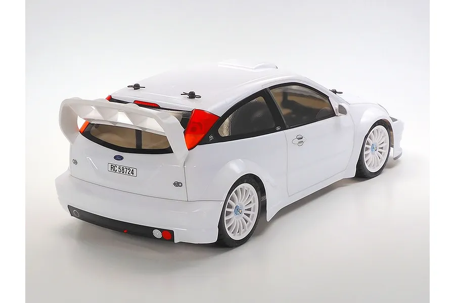 Rear three-quarter view of a white Tamiya 2003 Ford Focus RS RC car model on a plain white background.
