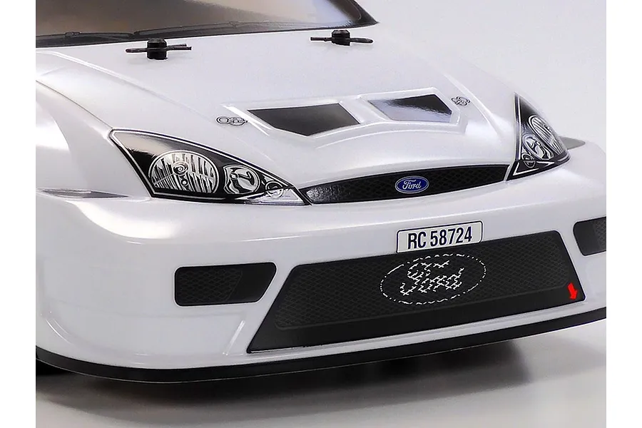 Close-up of the front end of a white Tamiya 2003 Ford Focus RS RC car body shell, showing headlights, grille, and hood details.