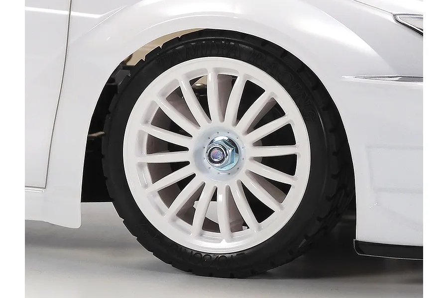 Close-up of a white Tamiya RC car wheel and tire on a white background.