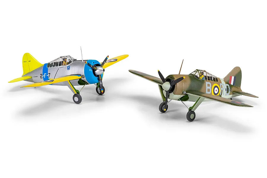 Two assembled and painted 1/72 scale Brewster Buffalo model aircraft on a white background, one in US Navy silver and yellow, the other in RAF camouflage.