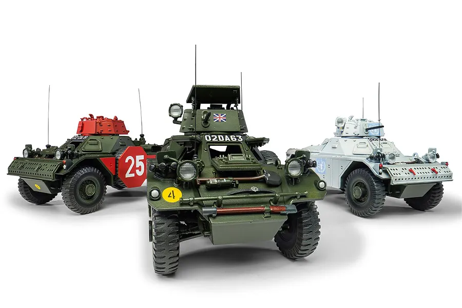 Three assembled and painted 1/35 scale Ferret Scout Car model kits in different liveries, including green, red-topped, and UN white versions.