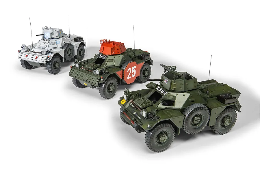 Three assembled and painted 1/35 scale Ferret Scout Car model kits in different liveries, displayed on a white background.
