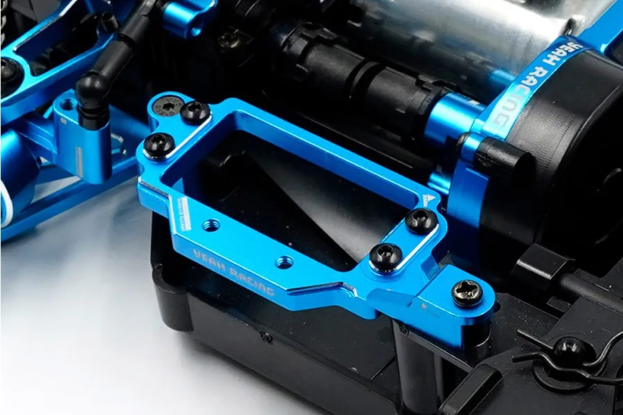 A blue anodized aluminium servo mount installed on an RC car chassis, featuring the Yeah Racing logo.