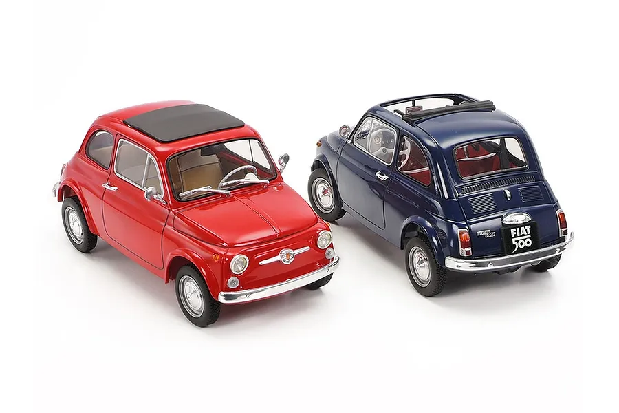 Two Tamiya 1/24 scale Fiat 500F model cars, one red and one dark blue, displayed on a white background.