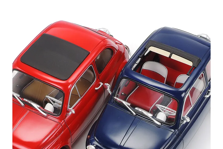 Two 1/24 scale Tamiya Fiat 500F model cars, one red and one blue, viewed from a high angle against a white background.