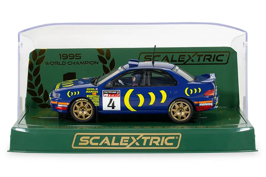 Scalextric 1/32 scale 1995 Subaru Impreza WRX slot car in blue with gold wheels, displayed in its original green and clear plastic display case.