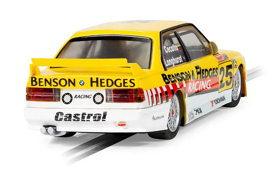 Rear three-quarter view of a yellow and white Scalextric 1/32 scale BMW E30 M3 slot car with Benson &amp; Hedges livery on a white background.