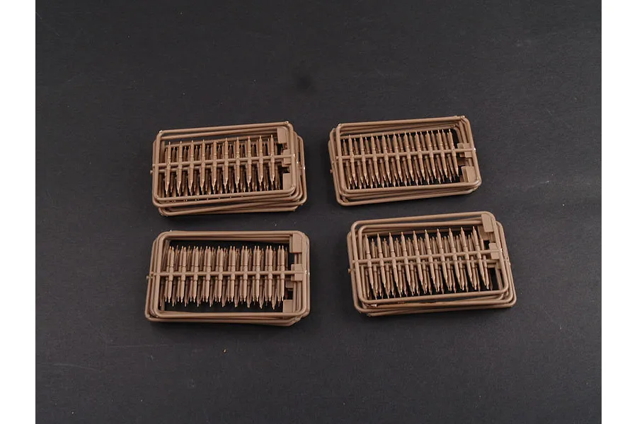Four sprues of brown plastic tank track links for a 1/35 scale model kit, arranged on a dark grey background.