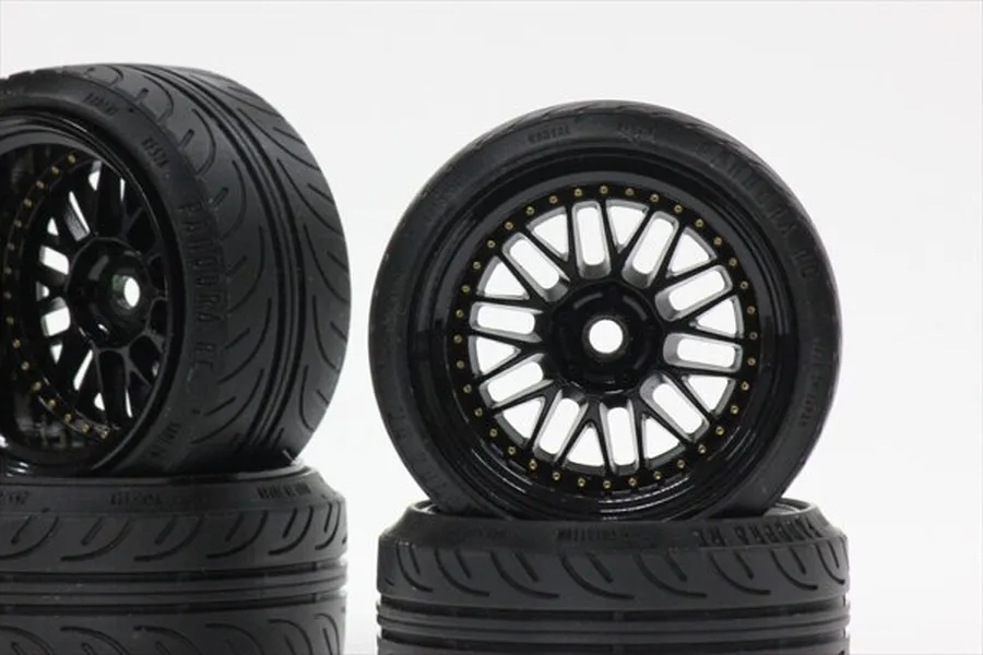 Two black RC car wheels with multi-spoke rims and treaded rubber tires stacked against a white background.