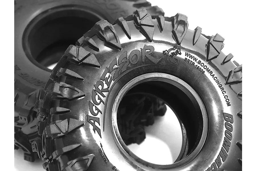 Close-up of two black Boom Racing 1.9 inch Aggressor crawler tyres showing the tread pattern and sidewall branding.