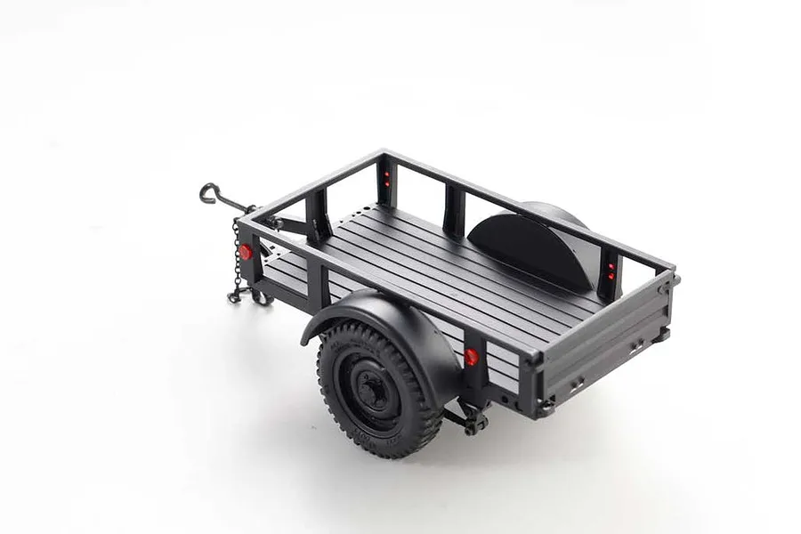 A black 1/18 scale utility trailer for RC vehicles, featuring a flatbed design, mudguards, and off-road tires, isolated on a white background.