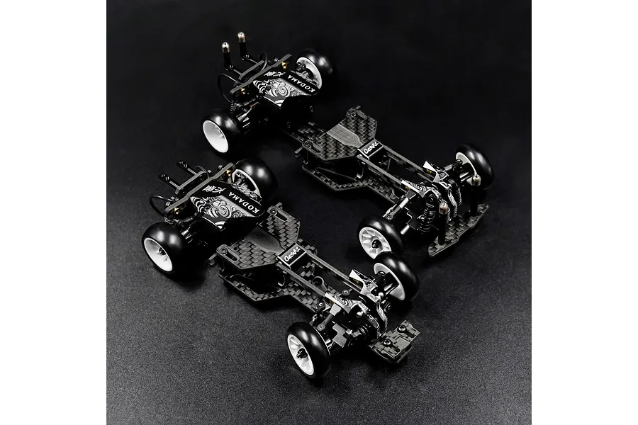 Two Yeah Racing Onisiki Kodama 1/24 scale RC drift car chassis rollers shown from a high angle on a black background.