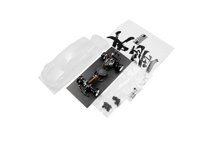 Yeah Racing Onisiki Kodama 1/24 scale RC drift car kit including chassis, clear body shell, instruction manual, and small parts bags.