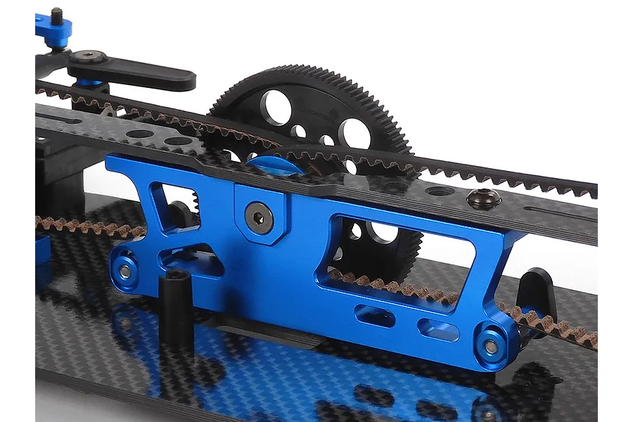 Close-up of the blue anodized aluminum motor mount and carbon fiber chassis plate on a Tamiya TRF421 RC touring car kit.
