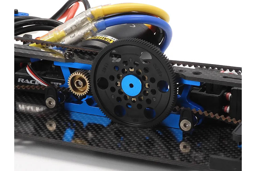 Close-up of the Tamiya TRF421 RC car chassis showing the spur gear, pinion, motor, and carbon fiber deck.