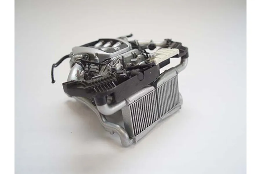A detailed 1/24 scale plastic model engine assembly for a Nissan GT-R, featuring silver and black components against a plain white background.