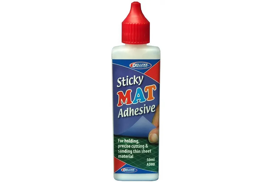 A bottle of Deluxe Materials Sticky Mat Adhesive, 50ml, featuring a red cap and blue and green label.