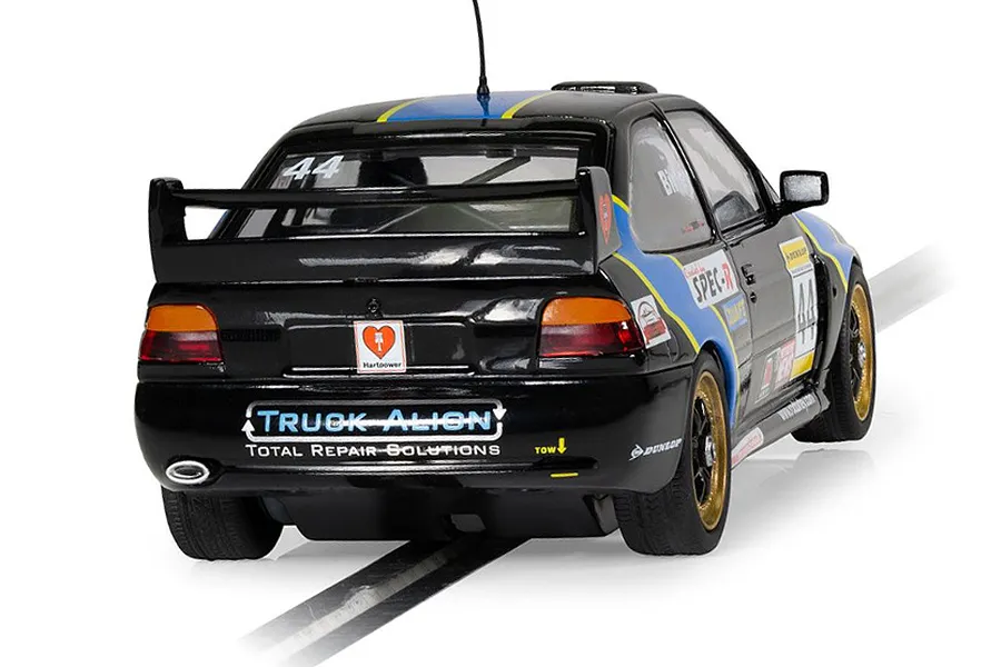Rear three-quarter view of a black Scalextric 1/32 scale Ford Escort Cosworth slot car with gold wheels and racing decals on a white background.