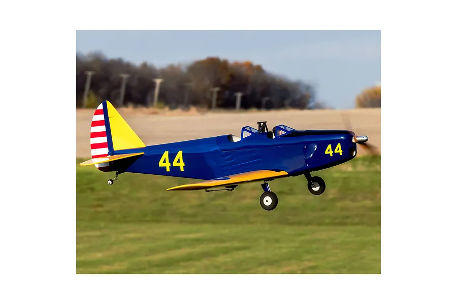 A blue and yellow Hangar 9 PT-19 RC warbird plane in flight over a grassy field.