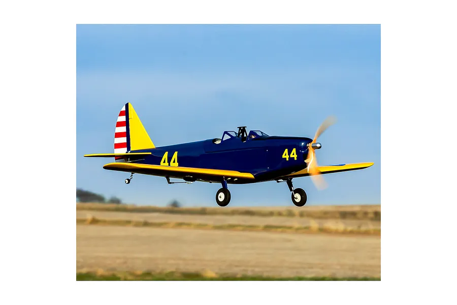 A Hangar 9 PT-19 RC warbird in flight against a blue sky, featuring a dark blue and yellow livery with the number 44 on the fuselage.