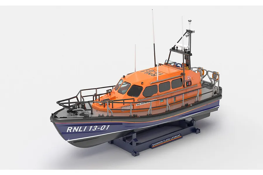 A 1/72 scale plastic model of an RNLI Shannon Class lifeboat, featuring a bright orange cabin and dark blue hull, mounted on a display stand.