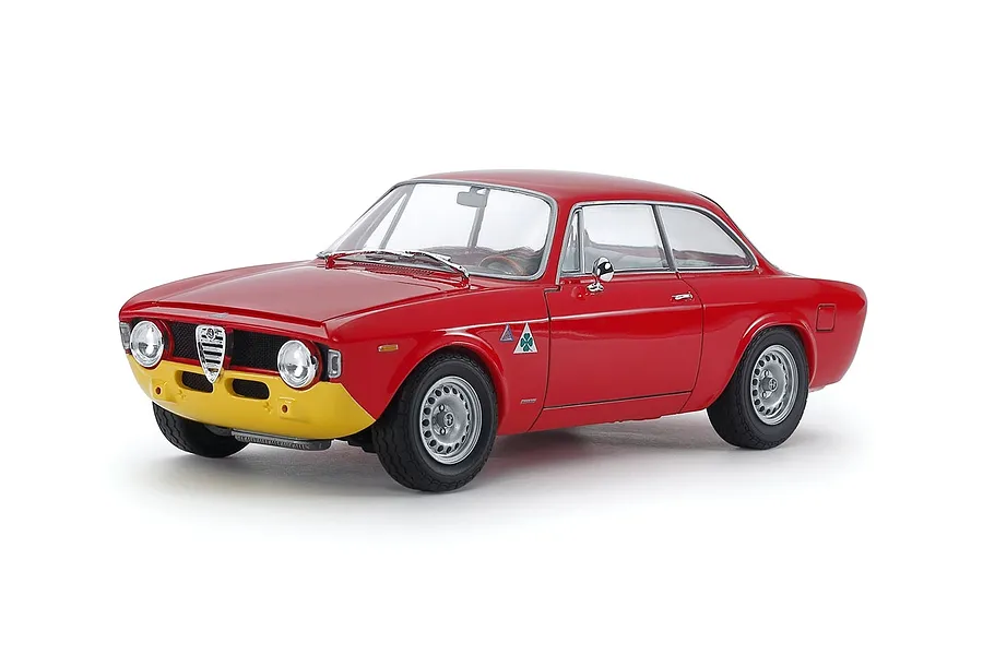 A studio shot of a 1/24 scale Tamiya Alfa Romeo Giulia GTA model car, painted red with a yellow front bumper and silver wheels.