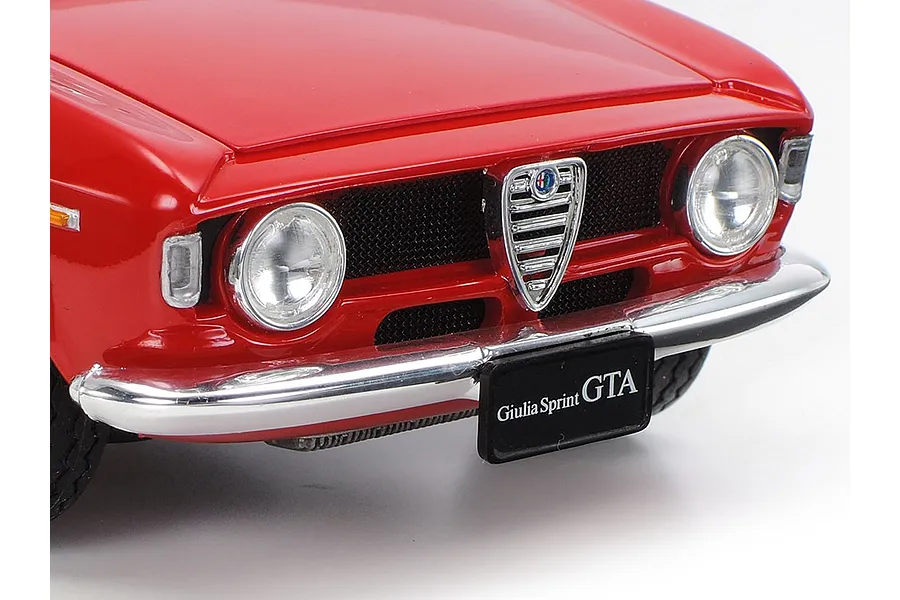 Close-up of the front end of a red Alfa Romeo Giulia Sprint GTA model car, showing the chrome grille, headlights, and bumper.