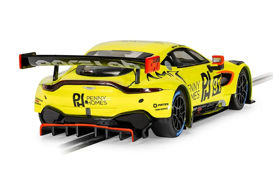 Rear three-quarter view of a bright yellow Scalextric Aston Martin GT3 Vantage slot car with Penny Homes livery on a track.