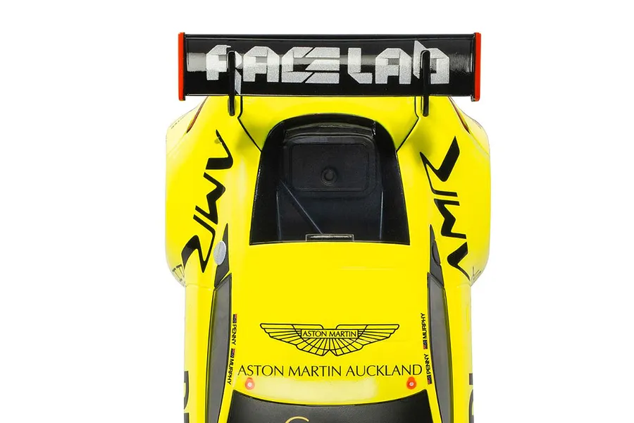 Top-down view of a bright yellow Scalextric Aston Martin GT3 slot car featuring black racing decals and a prominent rear wing.