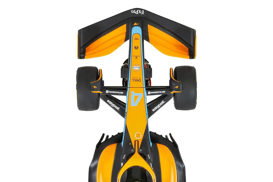 Top-down view of a Scalextric 1/32 scale McLaren MCL36 Formula 1 slot car in orange, black, and light blue livery.