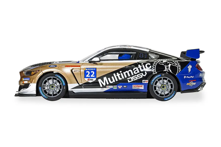 Side view of a Scalextric 1/32 scale Ford Mustang GT4 slot car in Multimatic livery with gold, black, and blue paint scheme.
