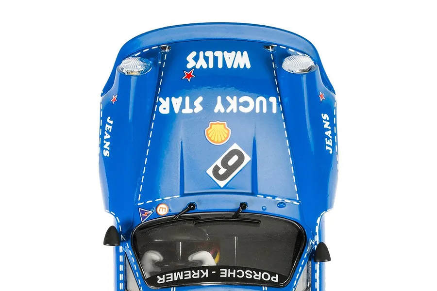 Top-down view of a blue Scalextric Porsche 911 Carrera RSR 3.0 slot car featuring Wallys Jeans branding and racing number 6.