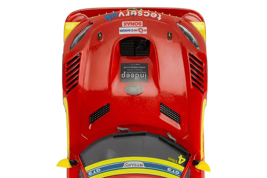 Top-down view of a red Scalextric 1/32 Mercedes AMG GT3 EVO slot car with yellow accents and various sponsor decals.