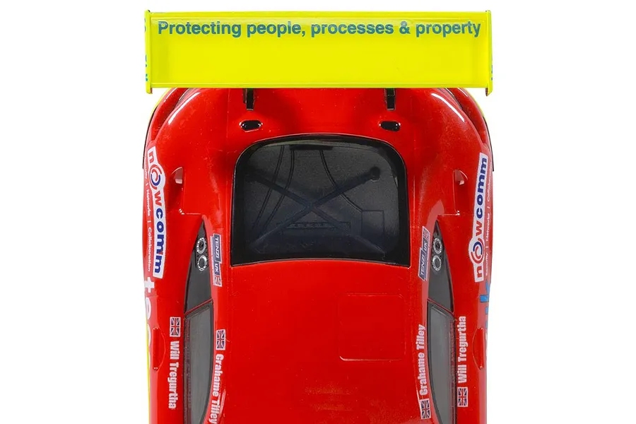 Top-down view of a red Scalextric Mercedes AMG GT3 EVO slot car with a bright yellow rear wing.
