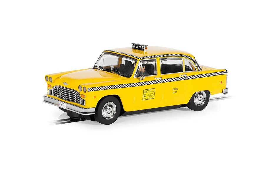 A 1/32 scale Scalextric model of a 1977 NYC yellow taxi cab on a slot car track, featuring checkered trim and detailed taxi signage.