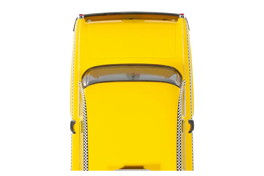 Top-down view of a bright yellow 1977 NYC taxi slot car model with checkered side trim against a white background.