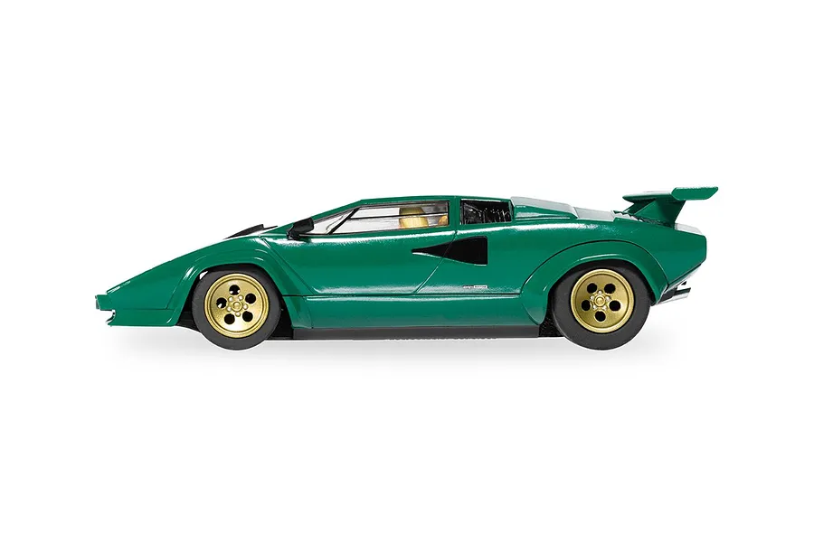 A side profile view of a green Scalextric 1/32 scale Lamborghini Countach slot car with gold wheels, isolated on a white background.
