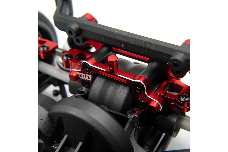 Close-up of a red anodized aluminium rear body post tower mount installed on an RC car chassis.