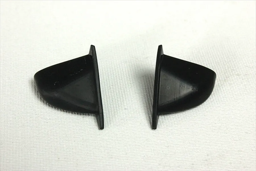 Two black unpainted aero door mirrors for a 1/10 scale RC car body shell, shown side-by-side on a white background.