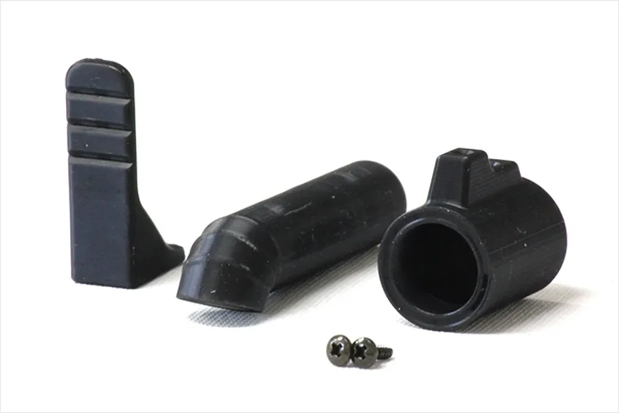 A set of unpainted black plastic RC car muffler parts including a mounting bracket, exhaust pipe, muffler tip, and two small screws on a white background.
